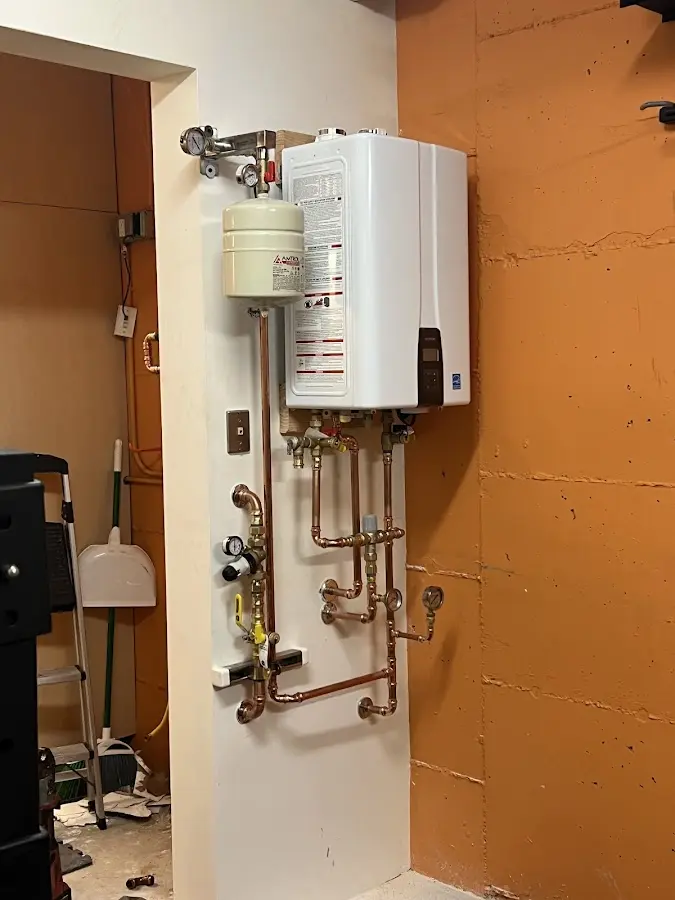 Plumbing technician inspecting water heater connections in Southport